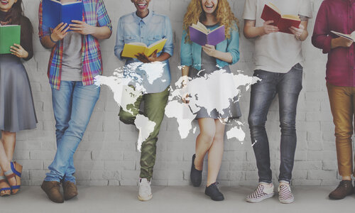 Sechs junge Erwachsene stehen nebeneinander vor einer weißen Backsteinwand und lesen Bücher in verschiedenen Farben. Ihre Gesichter sind größtenteils nicht sichtbar, der Fokus liegt auf den Büchern und ihrer Kleidung. Über das Bild ist eine transparente Weltkarte gelegt, die symbolisiert, dass Bildung Menschen weltweit verbindet.